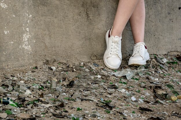 Teen's feet in a pile of broken glass and debris. troubled Teens