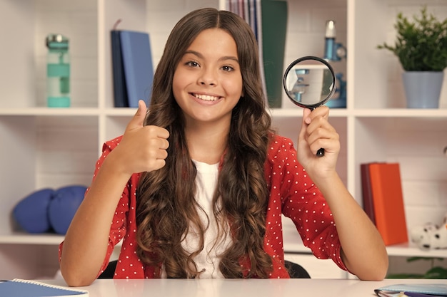 Teen school girl with magnifying glass knowledge Happy schoolgirl positive and smiling emotions