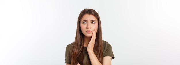 Teen woman pressing her bruised cheek with a painful expression as if she is having a terrible tooth