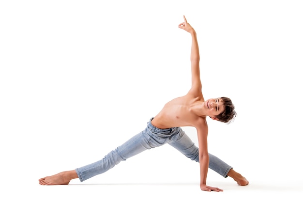 A teenage ballet dancer poses in a stretch barefoot, isolated against a white background.