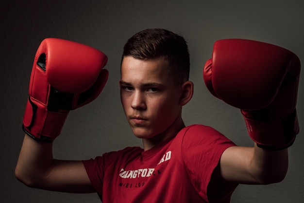 Photo a teenage boxer athlete is training to box on dark background aggressive sport