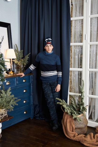 Teenage boy and a Christmas morning, a guy posing against the of the interior of a Christmas tree