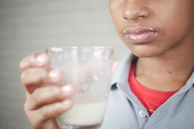 teenage boy drinking milk while sited