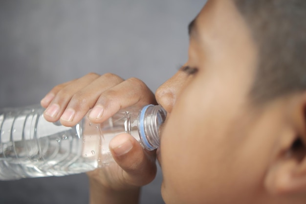 Мальчик-подросток пьет воду в замедленной съемке
