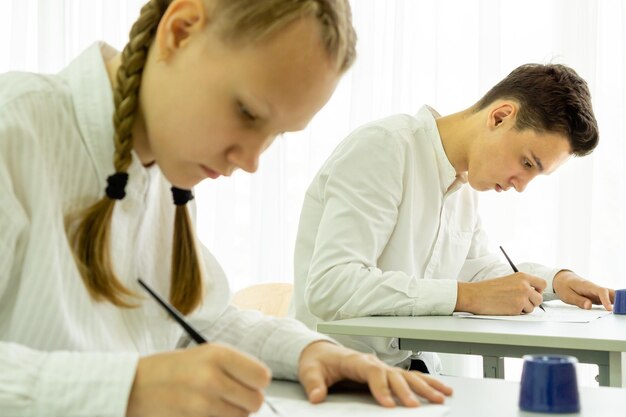 Подросток и девочка сдают экзамен по образованию