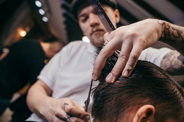 Teenage boy haircuts hairdresser in the Barber shop