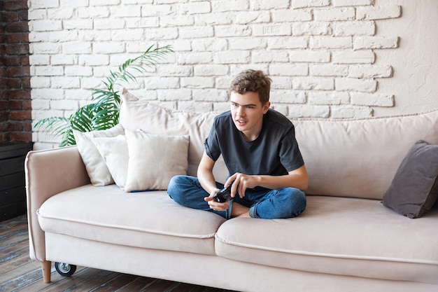 teenage boy playing video game at home