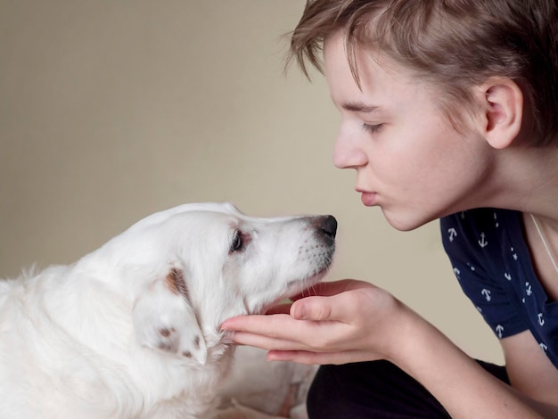 A teenage boy stroking a white dog Love for pets