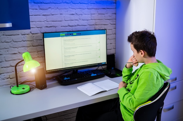 Teenage boy studing at home. Young boy at computer doing tests.Study in quarantine. Schoolboy during qurantine