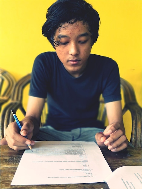 Photo teenage boy studying at home