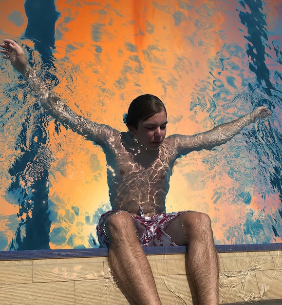 Photo teenage boy swimming at pool