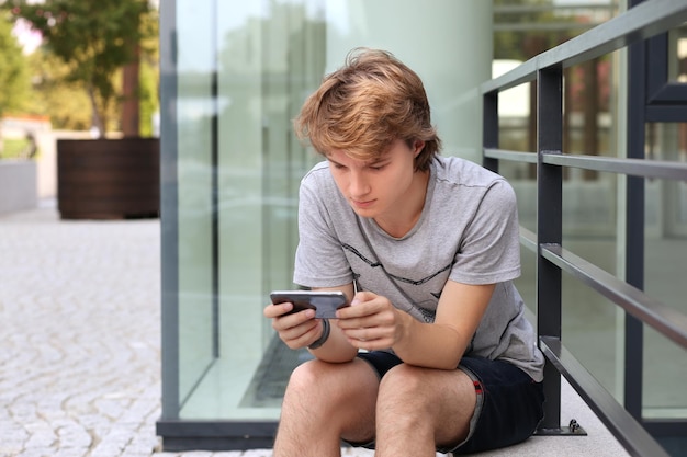 スマートフォンを使用する 10 代の少年