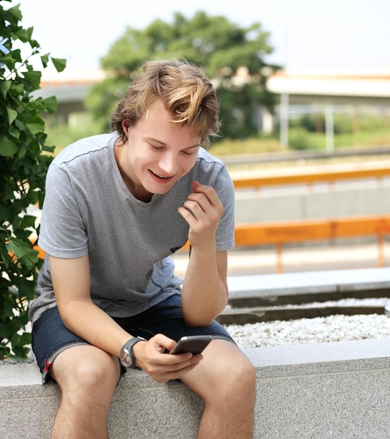 Photo teenage boy using smart phone