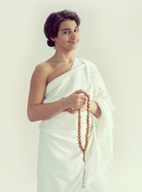 Teenage boy wearing Ihram for Hajj with rosary