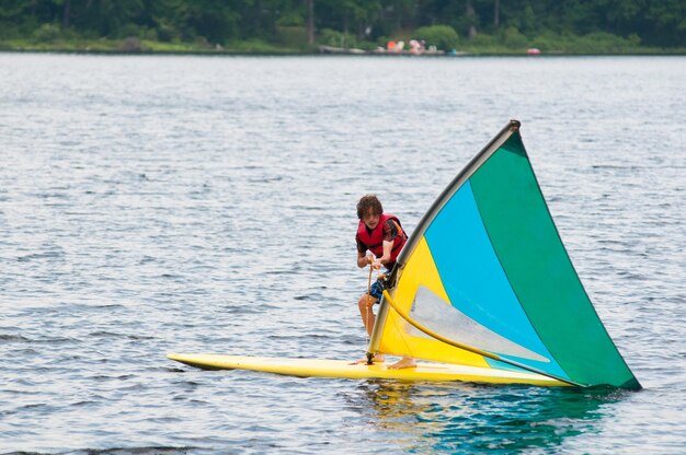 Foto ragazzo adolescente che fa windsurf in mare