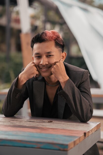 A teenage boy with blond hair poses very funny and cute when wearing a suit