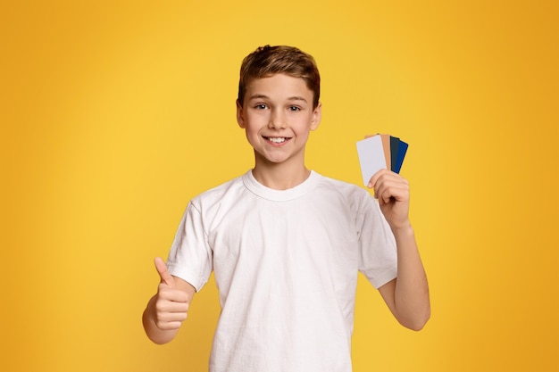 Teenage boy with lots of credit cards showing like gesture
