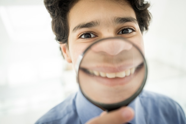 Photo teenage boy with magnifier