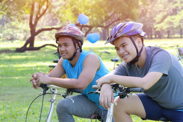 Photo teenage boys sitting on bicycles at park