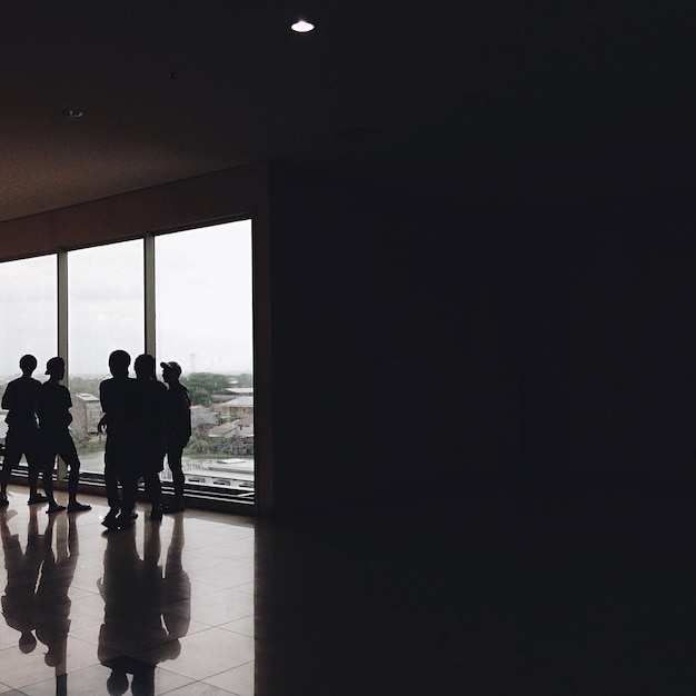 Teenage boys standing by glass window in room