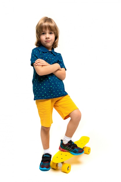 A teenage caucasian boy stands on yellow penny, picture isolated on white background