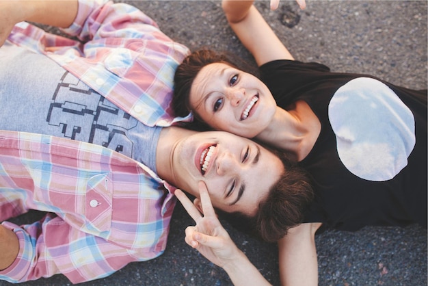 Фото Подростковая пара лежит и смеется