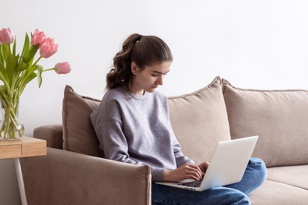 Photo a teenage female student is working on a laptop at home