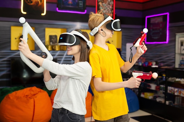 Teenage friends a boy and a girl with a virtual reality headset in glasses and hand motion