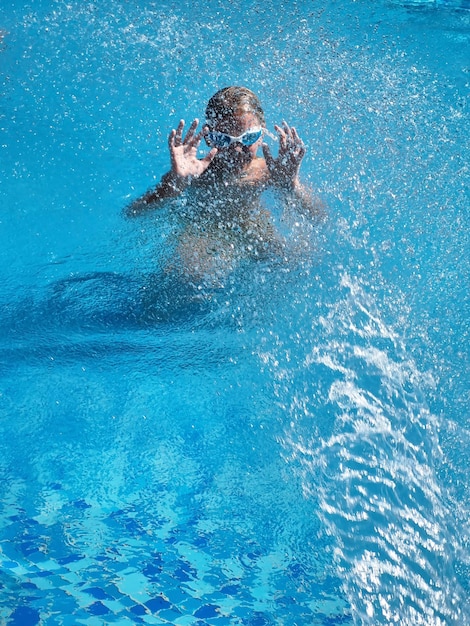 Teenage fun in swimming pool with splashing water