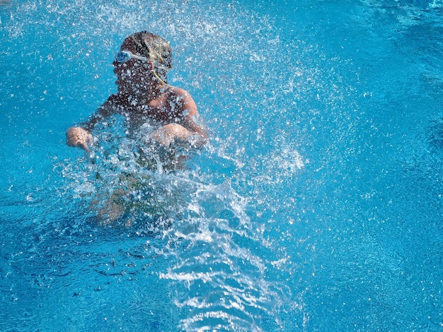 Teenage fun in swimming pool with splashing water
