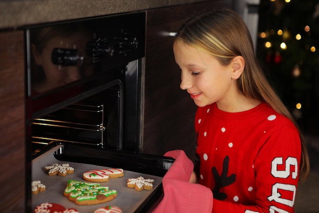 家でクリスマスジンジャーブレッドクッキーを焼く10代の少女