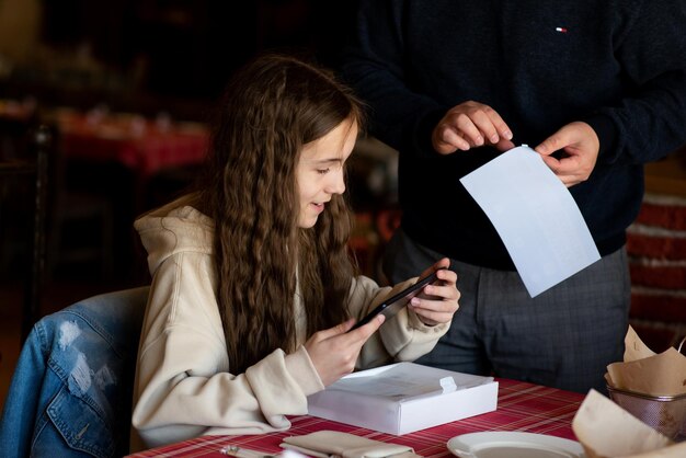 Un'adolescente in un bar disimballa un nuovo gadget generazione z