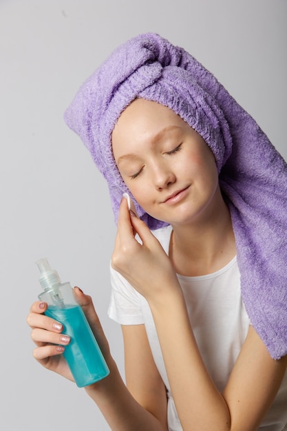 Teenage girl cleanses facial skin