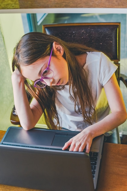 コンピューターの家庭教師で10代の少女。コンピュータ、遠隔学習、研究、ウェビナー、クラスレッスン