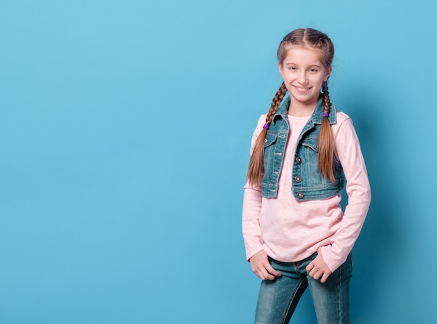 Teenage girl in confident pose over blue background