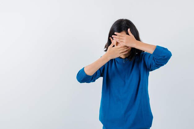 Teenage girl covering her eyes with hands on white background