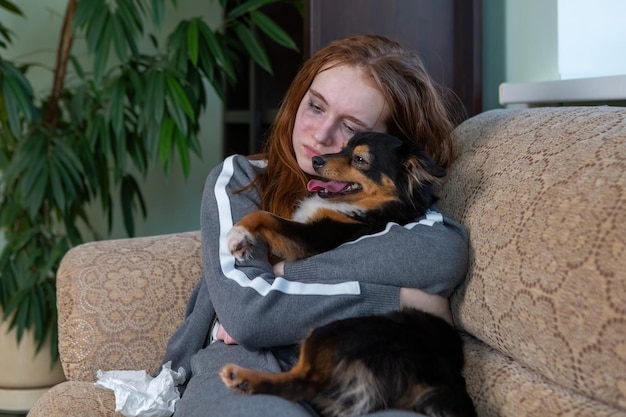 Teenage girl crying at home hugging a dog depression after breaking up with a guy