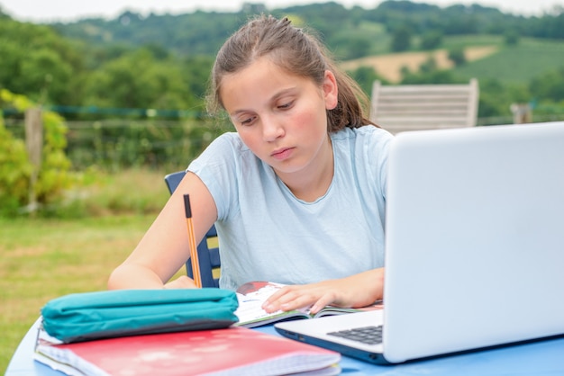 Teenage girl doing her homework in the garden