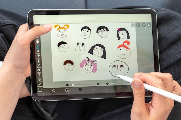 A teenage girl draws funny faces with an apple pencil on an apple tablet at an online training