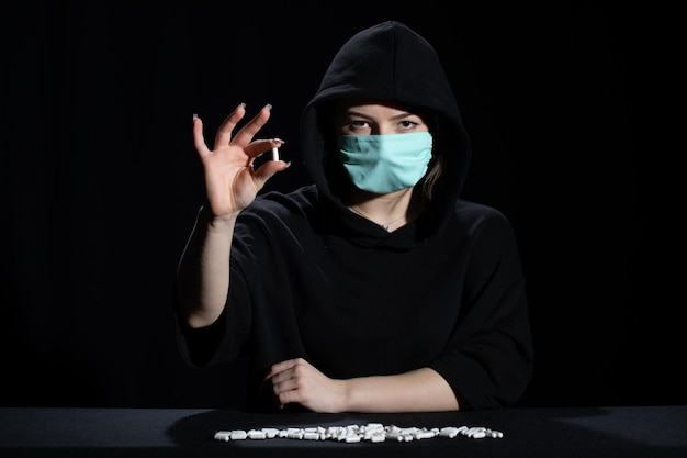 감염병 을 치료 하는 약 을 들고 있는 검은 옷 을 입은 십대 소녀