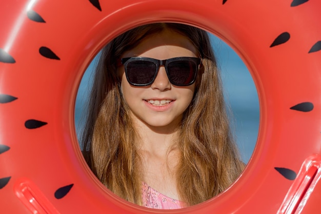 Photo a teenage girl in glasses looks through an inflatable ring close-up