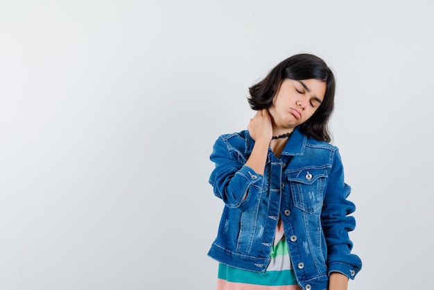 The teenage girl having neckache on white background