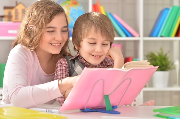 teenage girl  helping her little brother with homework