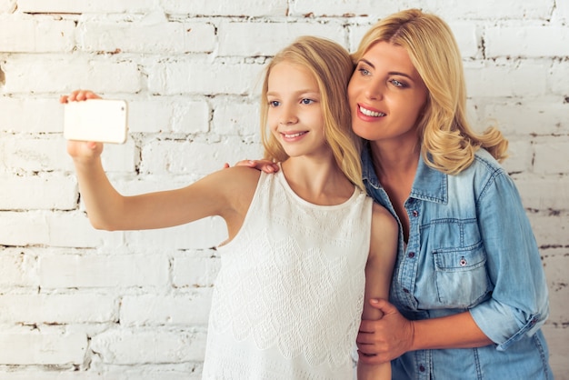 십 대 소녀와 그녀의 어머니는 selfie를 만들고있다.
