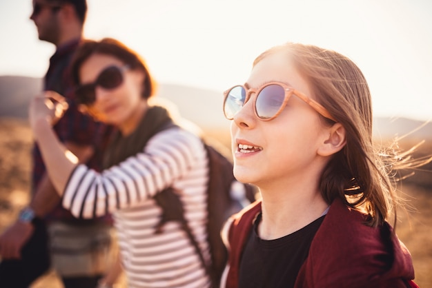 Teenage girl hiking on a mountain road with family