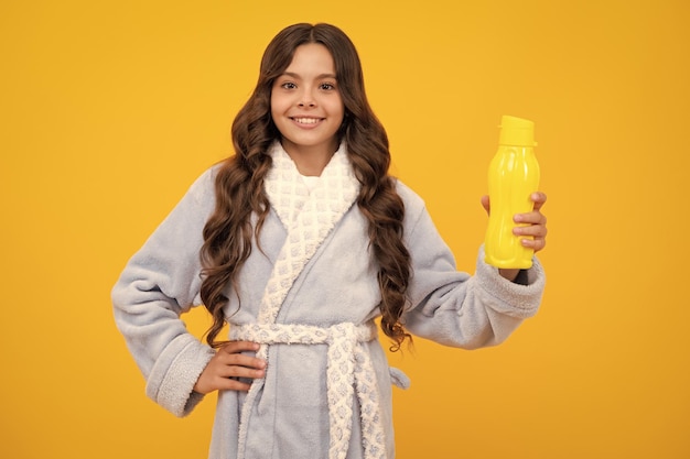 Teenage girl hold water bottle isolated on yellow background Water bottle and healthy life Health and water balance Drink and beverage morning concept