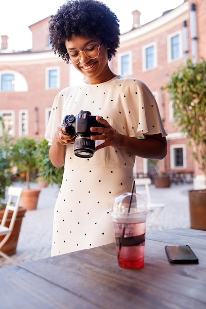 Photo teenage girl holding camera while standing outdoors