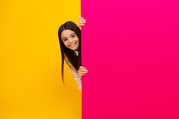 Teenage girl holds a blank for notification informing\
advertisement and sale markets and shops sales concept blank board\
for copy space happy kids face positive and smiling emotions