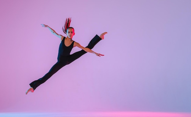 Фото Девочка-подросток в обтягивающем черном костюме танцует современную современную танцовщицу, изолированную от
