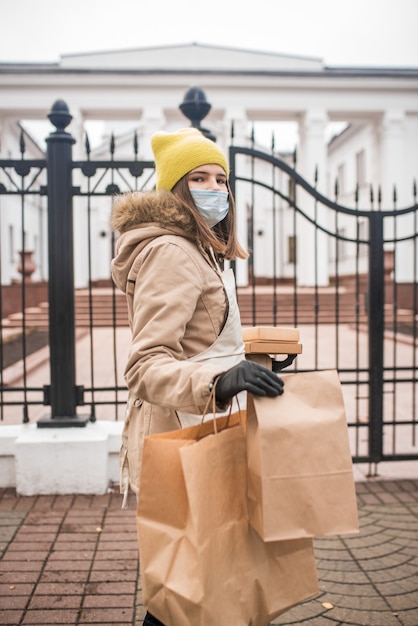 L'adolescente sta consegnando alcuni generi alimentari a una persona anziana, durante l'epidemia di coronovirus.